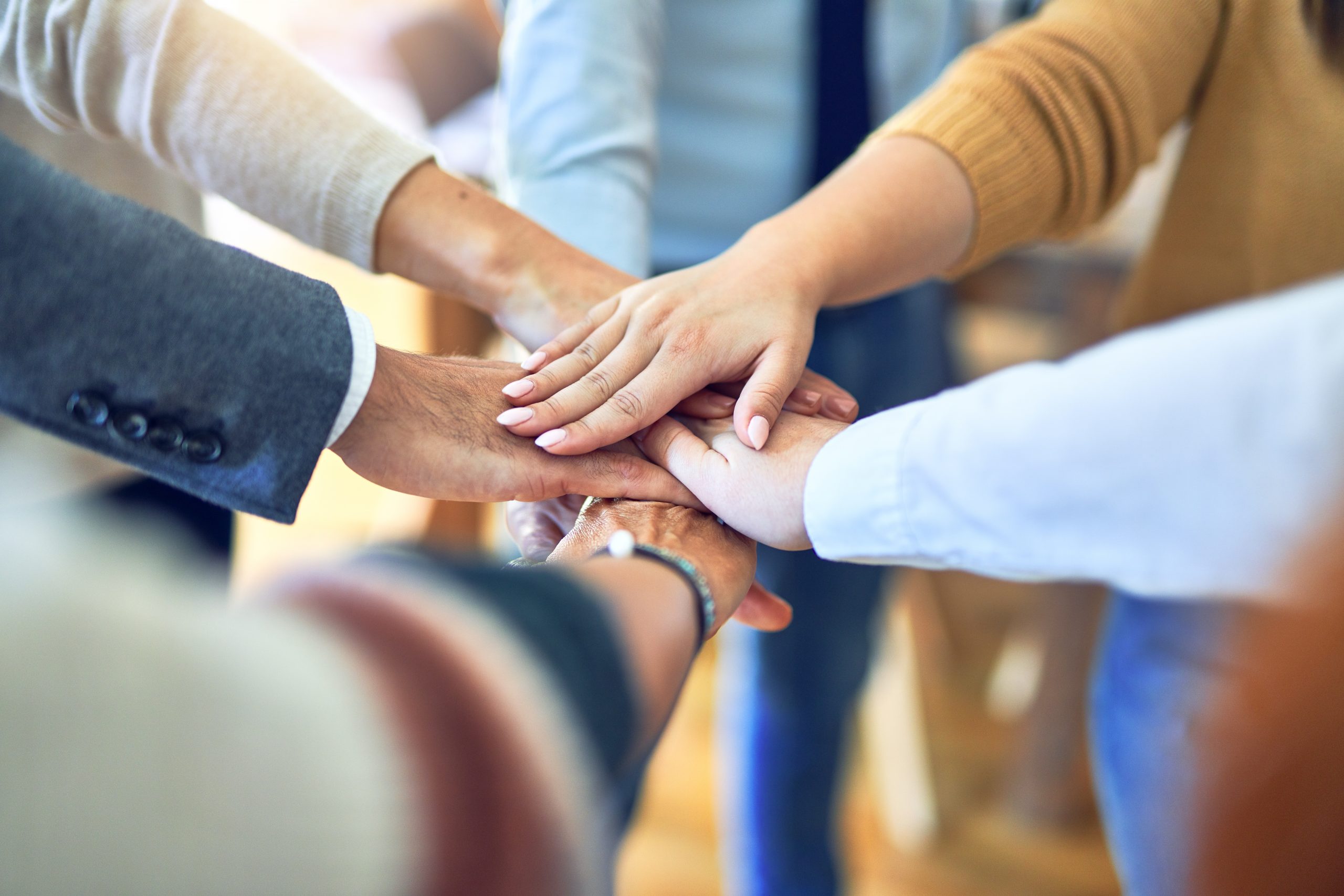 Group standing with hands together at the office Group standing with hands together at the office